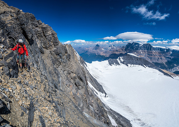 Ben near the top of the east face of the summit block with Mount Alberta, Woolley and the Twins in the distance.