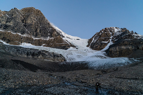 Steven crosses an outlet stream from the glacier.