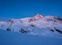 Mount Robson catches alpine glow as an ice avalanche thunders down the Robson Cirque in the foreground!