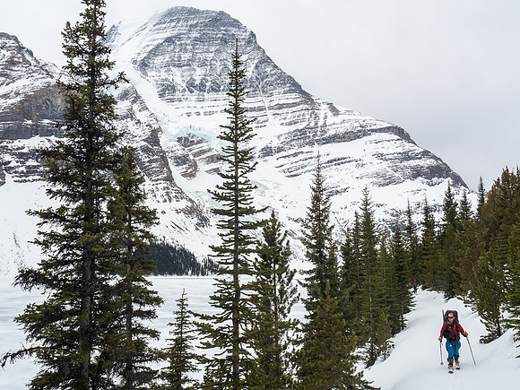 Ben skins the trail along Berg Lake behind me with Robson and the Mist Glacier looming on the left.