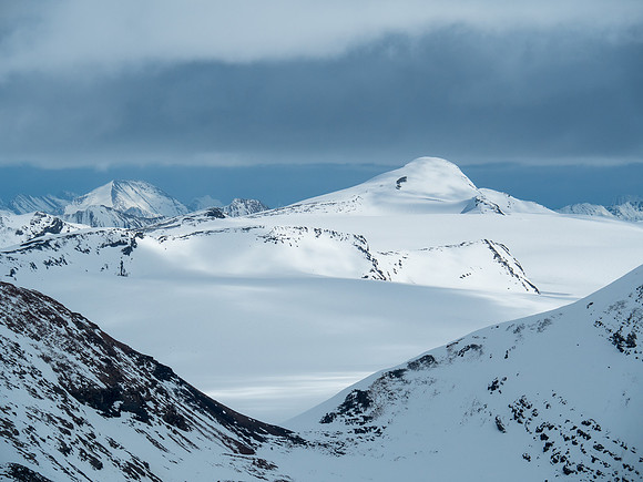 An unnamed snowy peak on the Reef Icefield. Snowbird Pass at lower foreground at center.