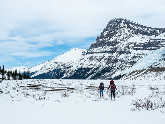 Skiing the flats before Berg Lake with the Berg Glacier on the right and Rearguard looming over it. Titkana Peak in the far distance at center.