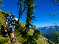 Harvey on the steeply grassed slopes beneath the start of the scrambling ridge.