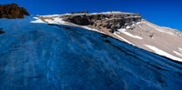 Phil is a tiny dot on the huge snow slope leading to the scree ledges above.