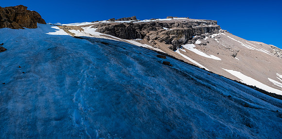Phil is a tiny dot on the huge snow slope leading to the scree ledges above.
