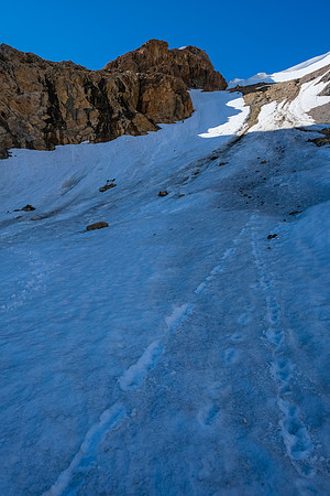 Phil is a tiny dot on the huge snow slope leading to the scree ledges above.