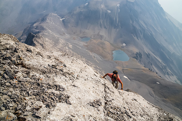 Unbelievable exposure down the SW face of Northover as Jon clambers up the crack that I found, leading to the summit. Northover Lakes far below.