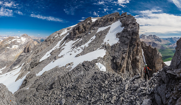 Phil at the final col before the summit block. The summit slopes are accessed easily via the gap through the cliffs, located just right of center.