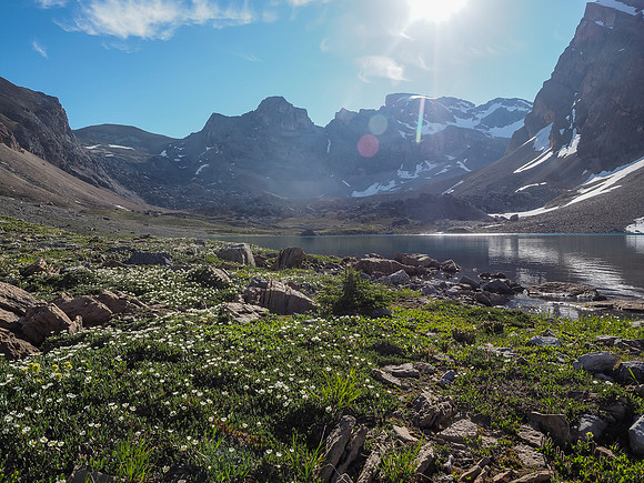 Carpets of wildflowers around Lake Alice with the blazing sun rising directly over our objective in the distance.