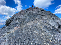 Downclimbing the outward flaring, loose, exposed crux.