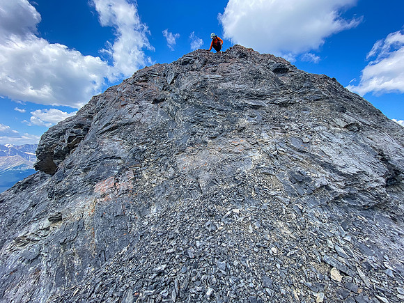 Downclimbing the outward flaring, loose, exposed crux.