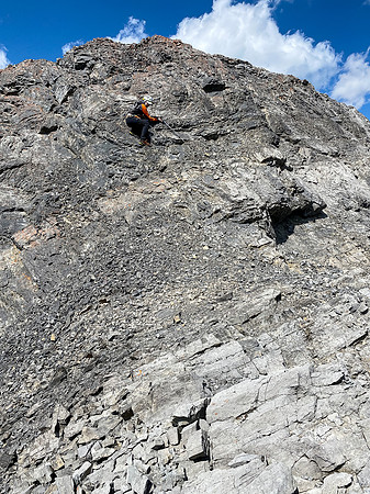 Downclimbing the outward flaring, loose, exposed crux.