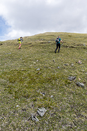 Ascending easy grassy west slopes to the false summit.