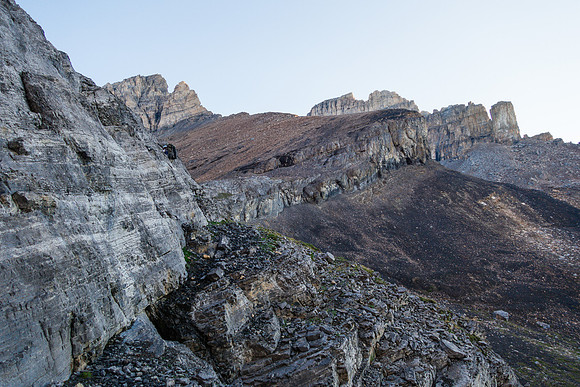 Ben scrambles up on climber's right of the snow patch, through the cliff band.
