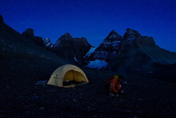 Raf gathers rocks to ensure his tent doesn't blow away. The west shoulder is fully exposed to the elements.