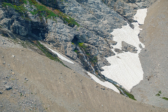 Interesting green slopes near running water. Note the cave.