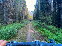 Biking up (and down) the approach trail as it circles Spray Lake.