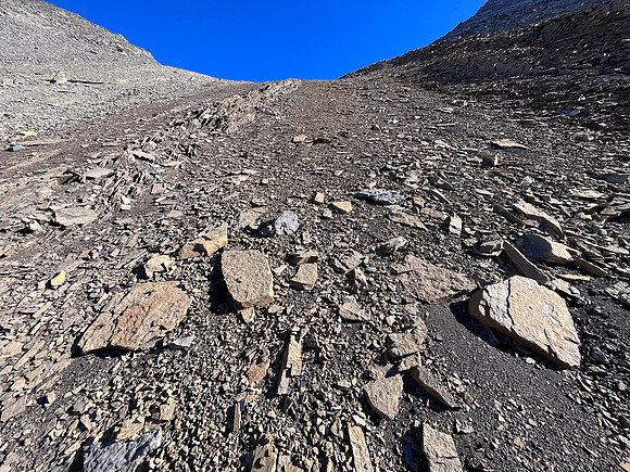 Ascending south scree slopes to the upper col under the west face.