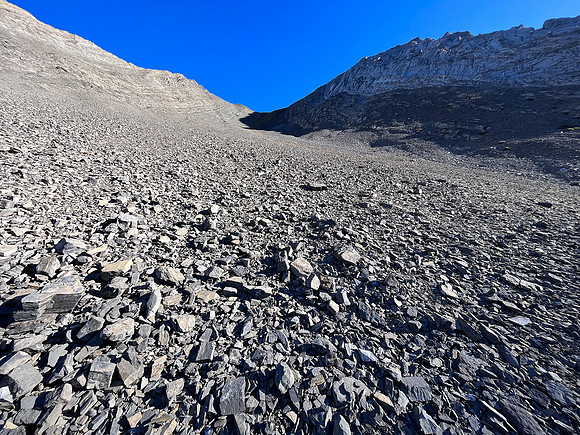 Ascending south scree slopes to the upper col under the west face.