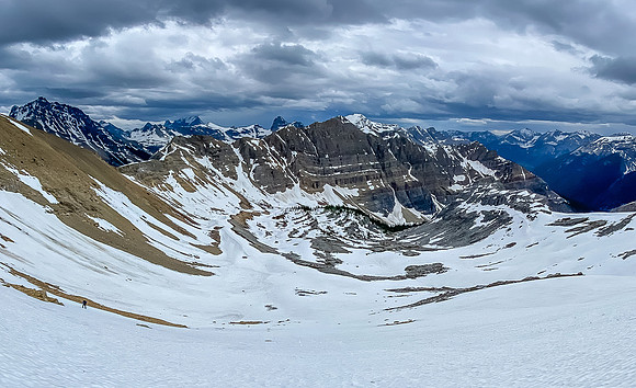 Traversing a mix of scree and hard pan to the low col at left.