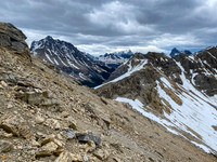Traversing a mix of scree and hard pan to the low col at center.
