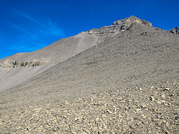 Rod exits the giant scree bowl towards the descent slopes to the first shoulder.