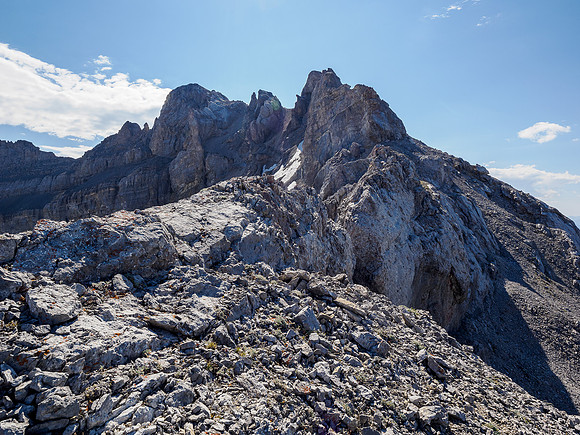Descend here to the right avoid the NW ridge and traverse rubble slopes under the false summit left.
