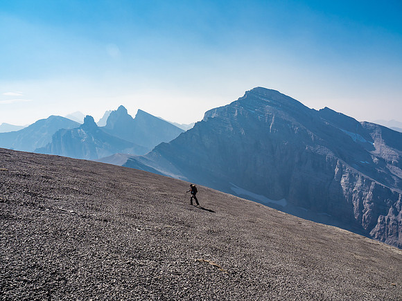 Wietse comes up the SW summit ridge with The Elevators and Apis Peak visible to the south.