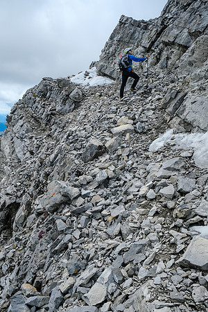 A wider but more exposed scree ledge over the east face.