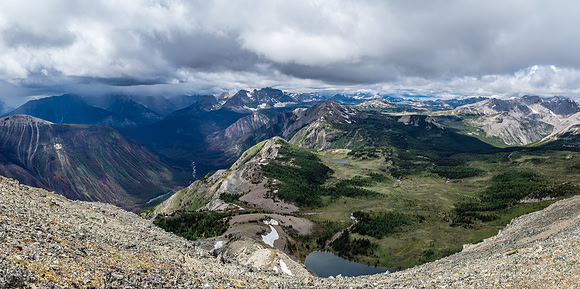 Citadel Lake sneaks into view as I walk towards the north end of the summit block. There's also a fast moving storm approaching at left here - time to bail!