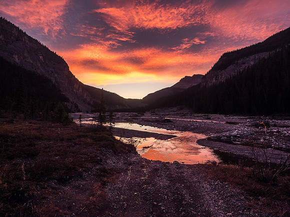 Looking back at one of the numerous river crossings as day breaks dramatically around us.