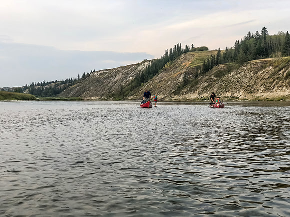 Looking back at Mike and Calvin walking their boats through a shallow section.