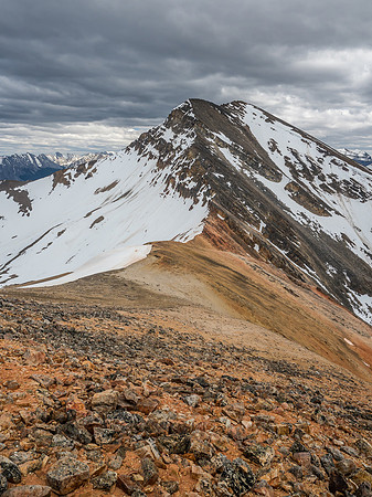 Descending colorful scree and rock towards the Two O'Clock Peak col from Landslide Peak's SE ridge.