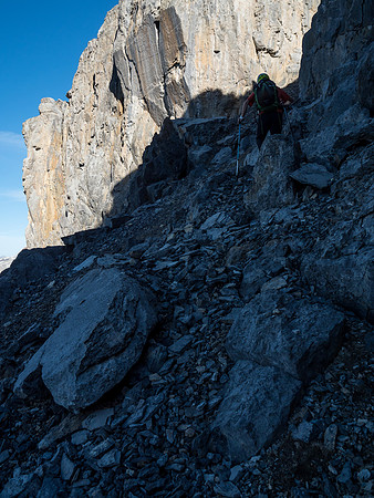 Phil makes his way over loose, blocky terrain to the bottom of the break in the cliff band.