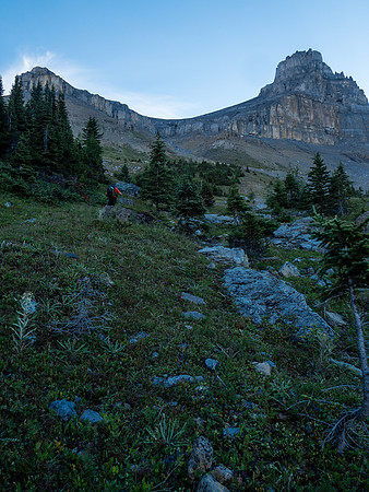 Phil grinds his way up grassy slopes to the rocky headwall above.