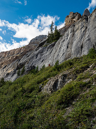 Looking up at Phil beneath cliffs - the route up the headwall isn't as obvious as you'd think due to many different routes and tracks.
