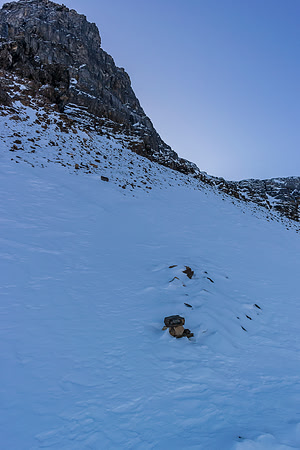 The tracks end. Boo. Note the cairn and the faint sign of a buried track in the scree underneath the snow cover.
