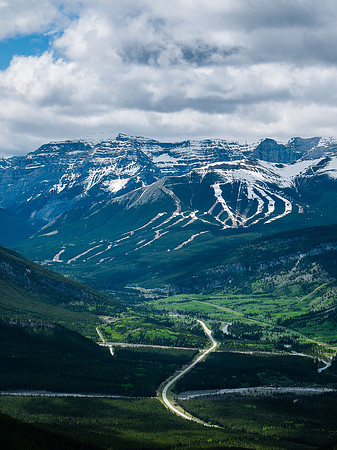 Green Spring in the valley bottom with snow on the Nakiska ski hill above.