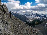 Some exposure and loose scree before turning climber's left up a steep scree gully.