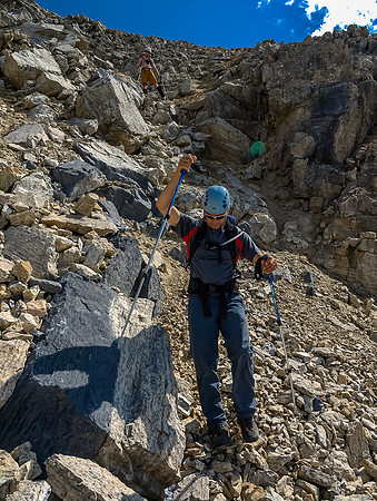 Careful down climbing on very loose scramble terrain through the upper cliff bands beneath the summit block.