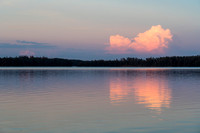 A distant thunderstorm reflects in Indian House Lake.