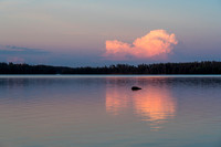 A distant thunderstorm reflects in Indian House Lake.