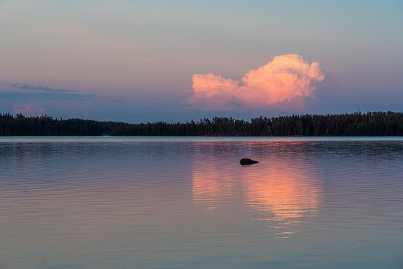 A distant thunderstorm reflects in Indian House Lake.