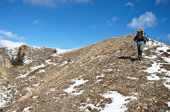 Wietse with the summit cairn (and flag) above.