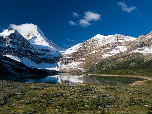 Assiniboine with clouds streaming off the summit and Lake Magog in front.